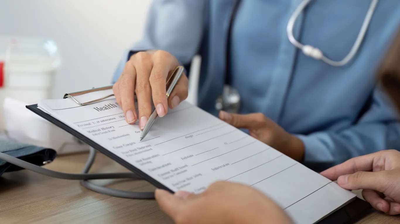 Médico mostrando prontuário ao paciente durante consulta.